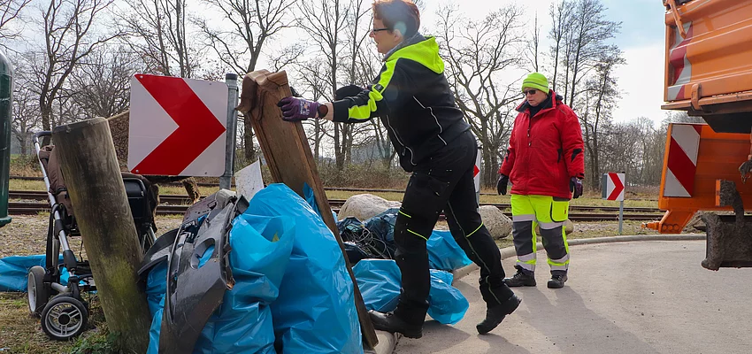 Müllsäcke werden auf die Ladefläche eines LKW geladen.