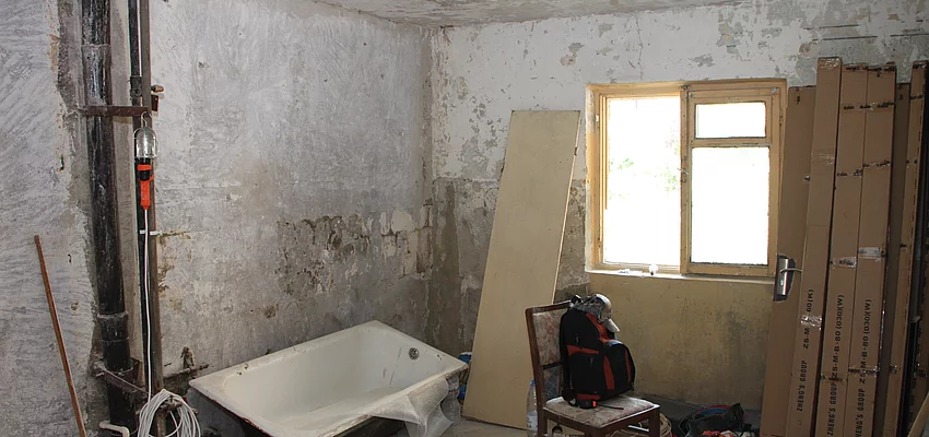 Symbolbild Renovierung Ein Zimmer wird umgebaut. Leitungen sind zu sehen, die Wände sind unverputzt. Eine Badewanne steht im Raum.